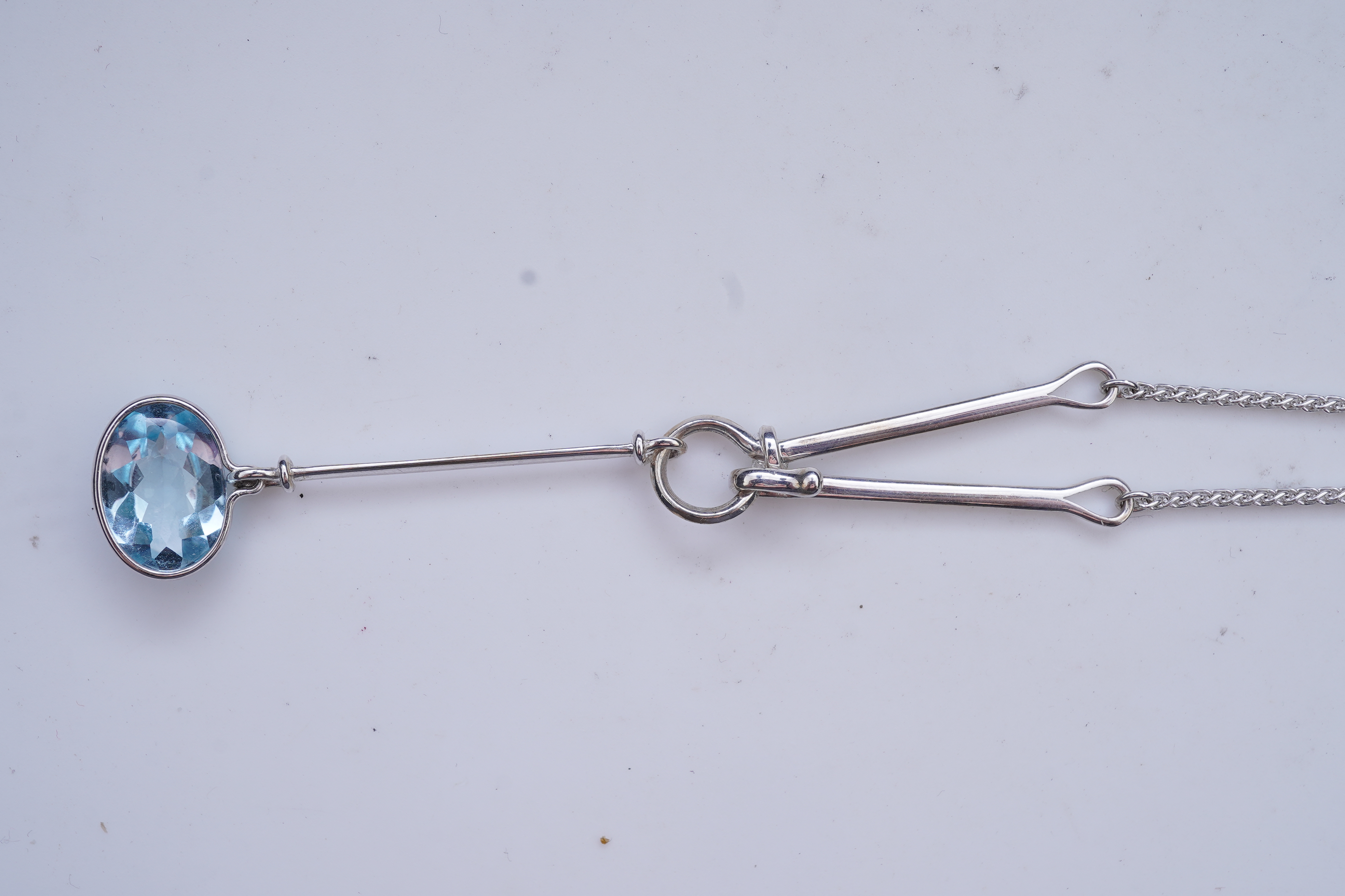 Georg Jensen, a blue topaz necklace, centring on a hook clasp suspending an oval blue topaz pendant, pendant length 5.5cm, necklace length 43cm, stamped GJ for Georg Jensen, 925S and European convention assay marks for s